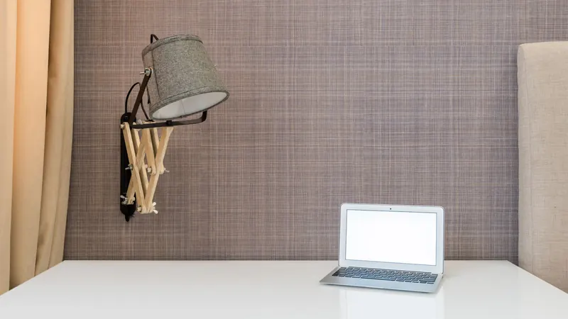 Schreibtisch mit Laptop und Lampe im Büro – AfA-Tabelle für die GmbH: Büroausstattung abschreiben