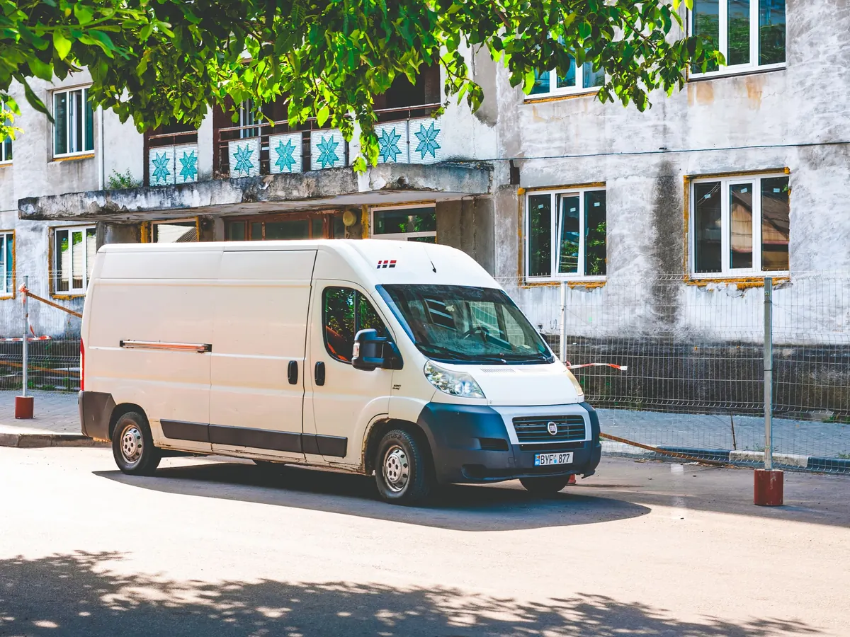 Ein weißer Lieferwagen parkt an einer Straße – Abschreibung eines Fahrzeugs in der GmbH nach der AfA-Tabelle