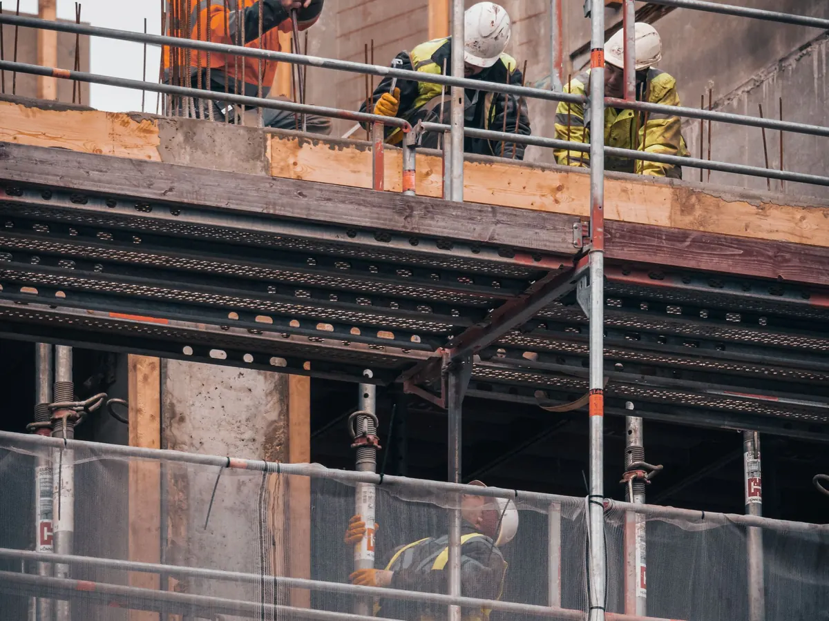 Bauarbeiter auf einem Gerüst an einem Neubau