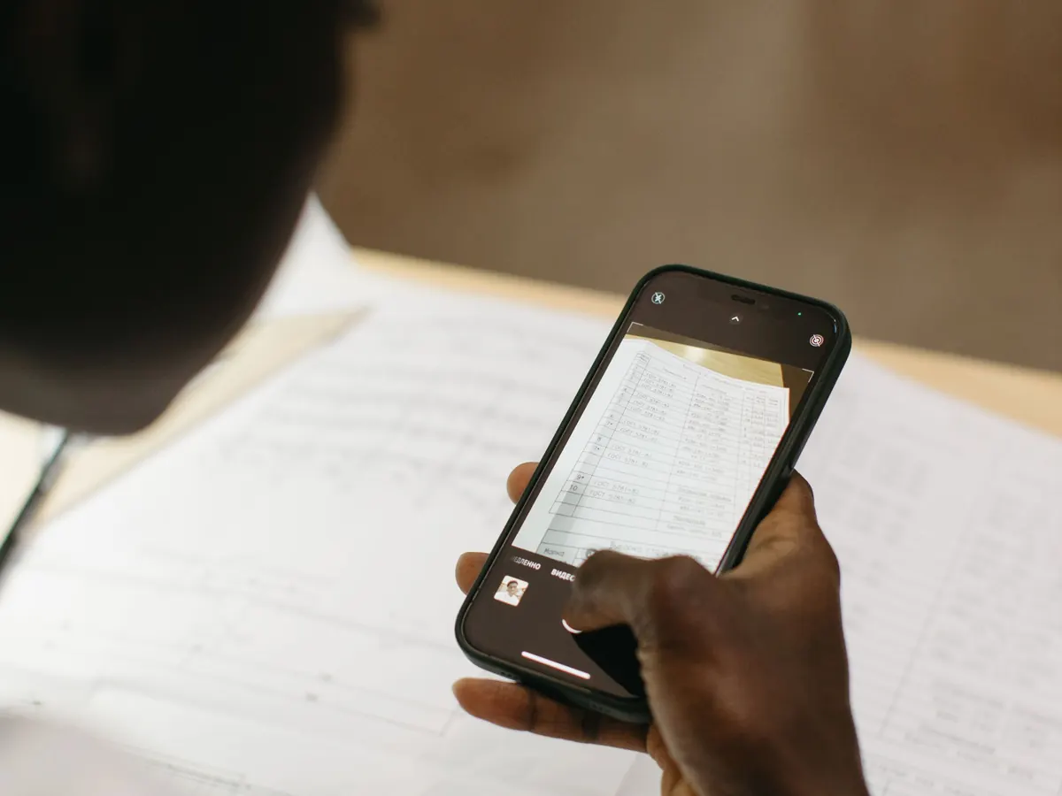 Ein Telefon fotografiert ein Blatt Papier – den Bewirtungsbeleg mit dem Telefon erfassen