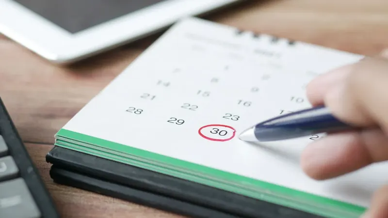 Tischkalender mit rot eingekreistem Datum und Kugelschreiber – die Termine im ersten Geschäftsjahr der UG