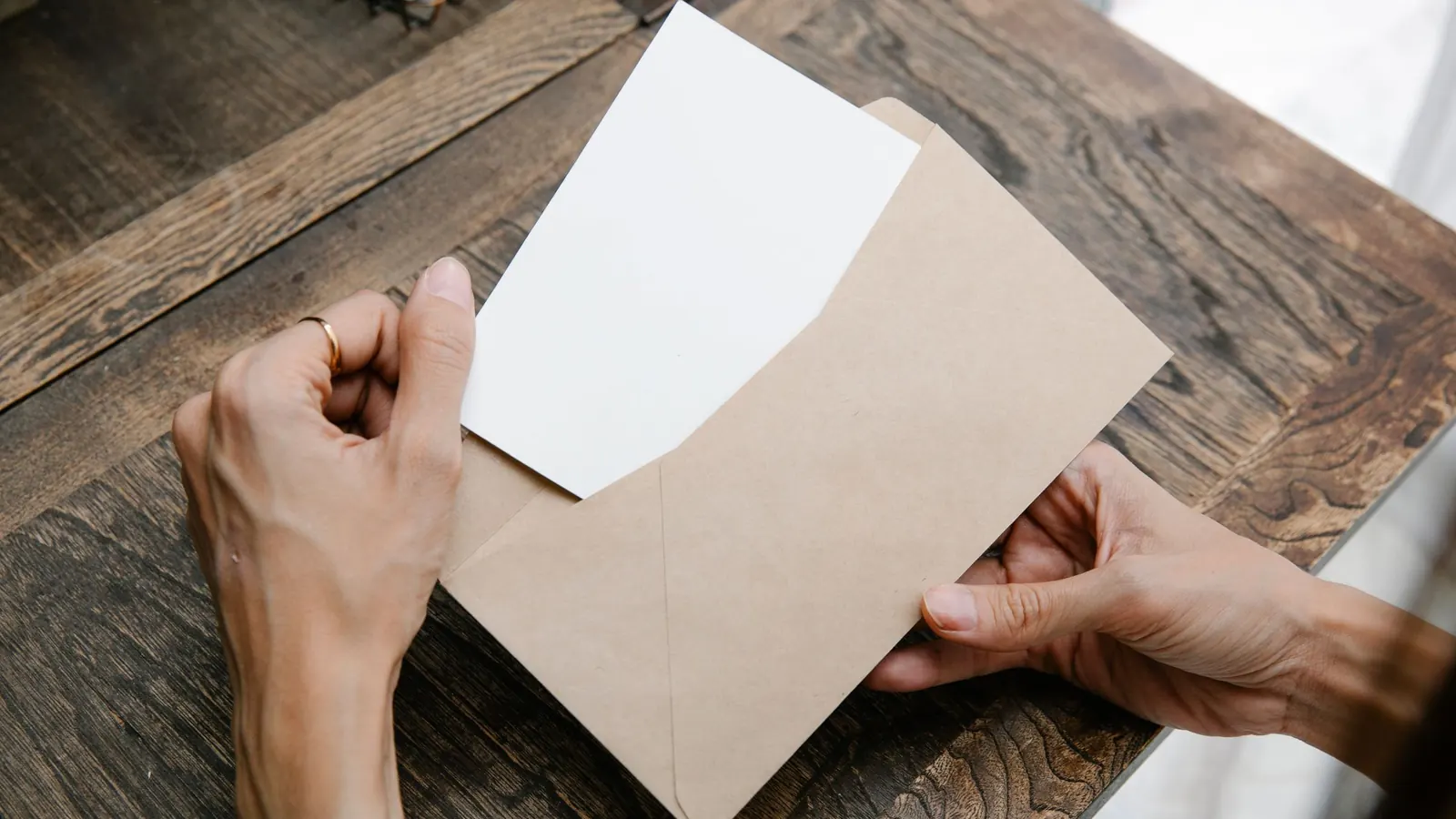 Hände ziehen einen Brief vom Finanzamt aus dem Umschlag – Bescheid, Frist und nächste Schritte für die GmbH
