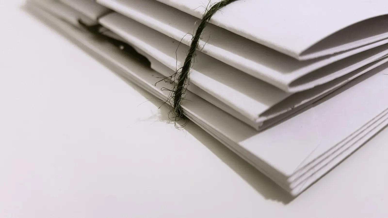 Ein mit Schnur gebündelter Stapel Briefumschläge – IHK-Beitrag der GmbH: der Beitragsbescheid in der Post