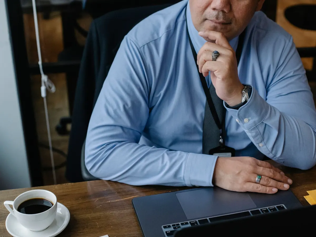 Ein Geschäftsführer sitzt nachdenklich am Laptop und überlegt, was der Jahresabschluss seiner GmbH kosten wird