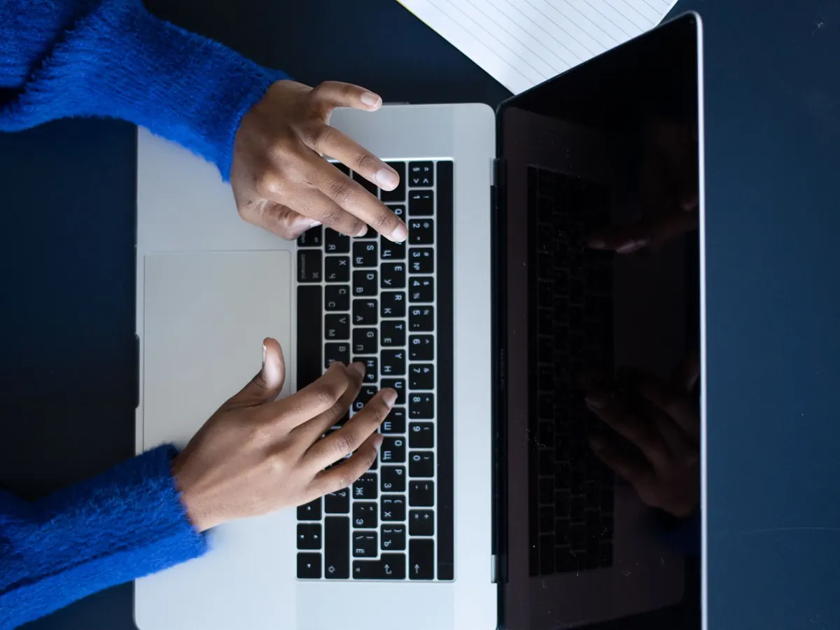 Hände tippen am Laptop von oben gesehen – Transparenzregister selbst eintragen