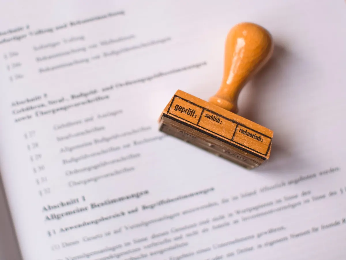 Stempel „geprüft“ auf einem Dokument – die Bilanz, auf der die Erhöhung beim Wechsel von der UG in GmbH beruht