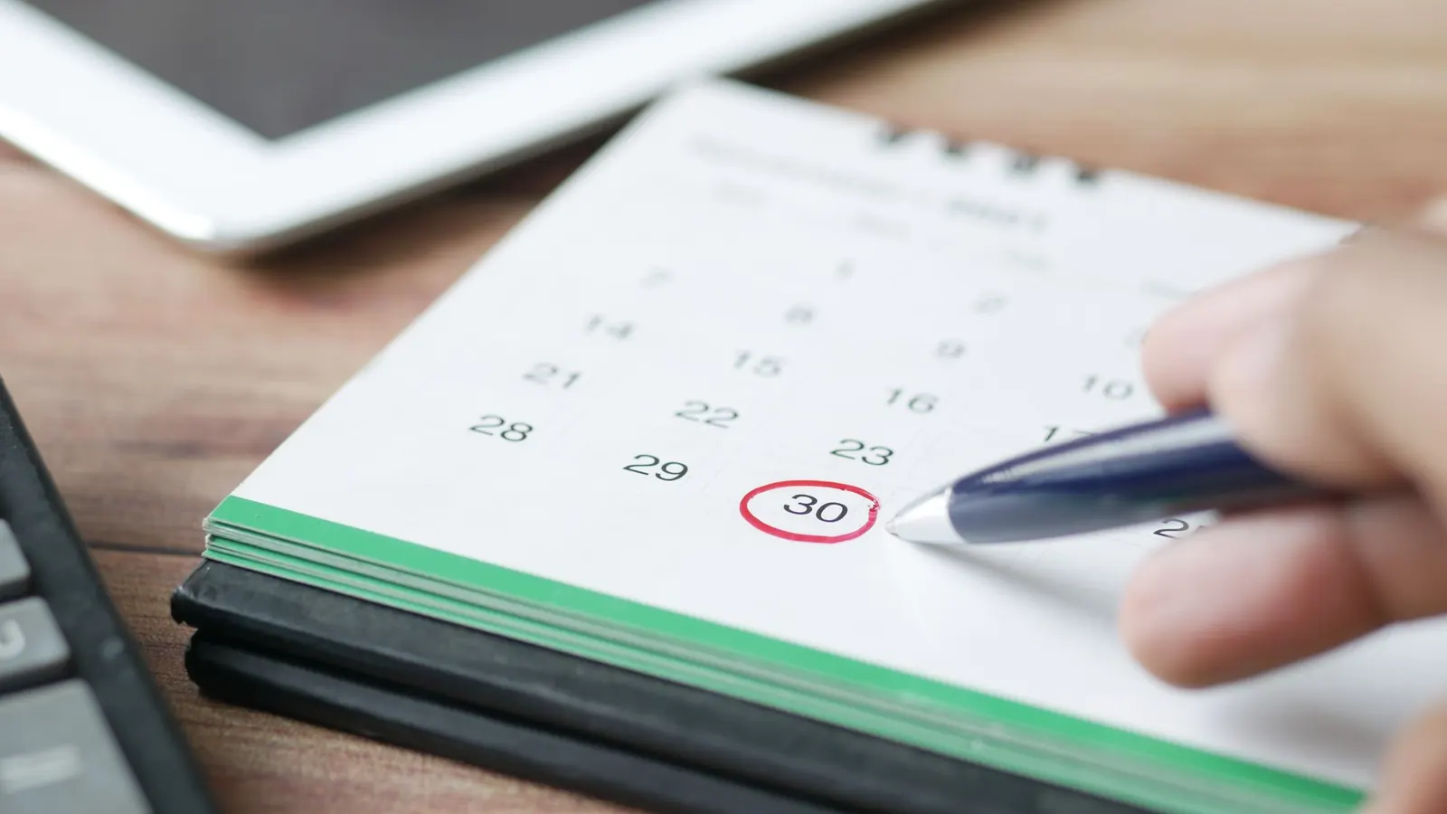 Ein Datum im Kalender wird mit dem Stift eingekreist – die Frist der Umsatzsteuervoranmeldung der GmbH
