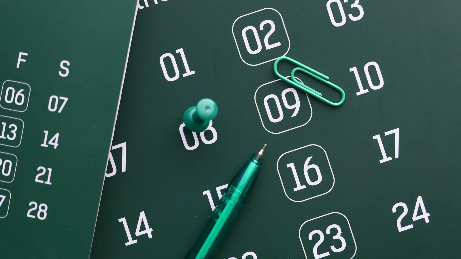 Kalenderblatt mit eingekreisten Tagen, Stift und Büroklammer – Termine der Steuervorauszahlungen der GmbH