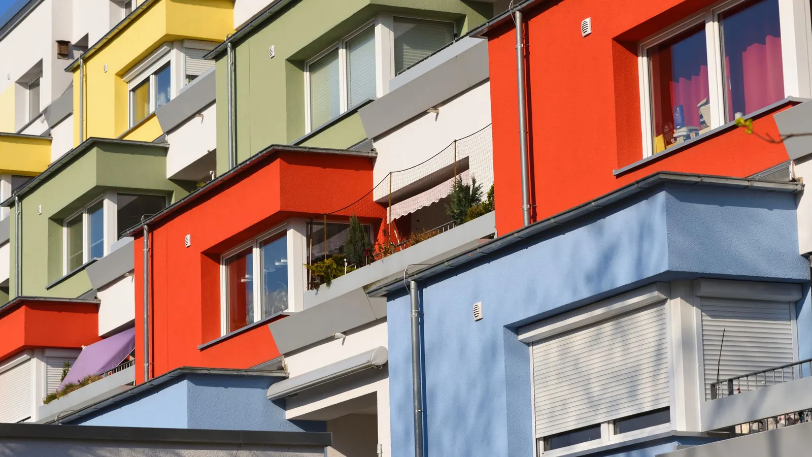 Farbige Fassade eines Mehrfamilienhauses mit Balkonen – vermögensverwaltende GmbH mit Immobilien und Gewerbesteuer