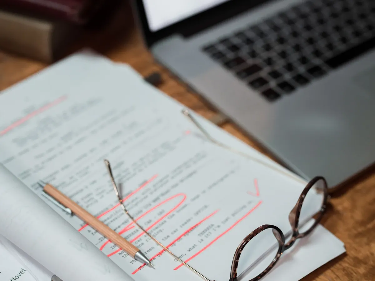 Ausgedruckte Rechnung mit Brille vor dem Laptop – bei ZUGFeRD lesen Menschen das PDF, Programme die Datei
