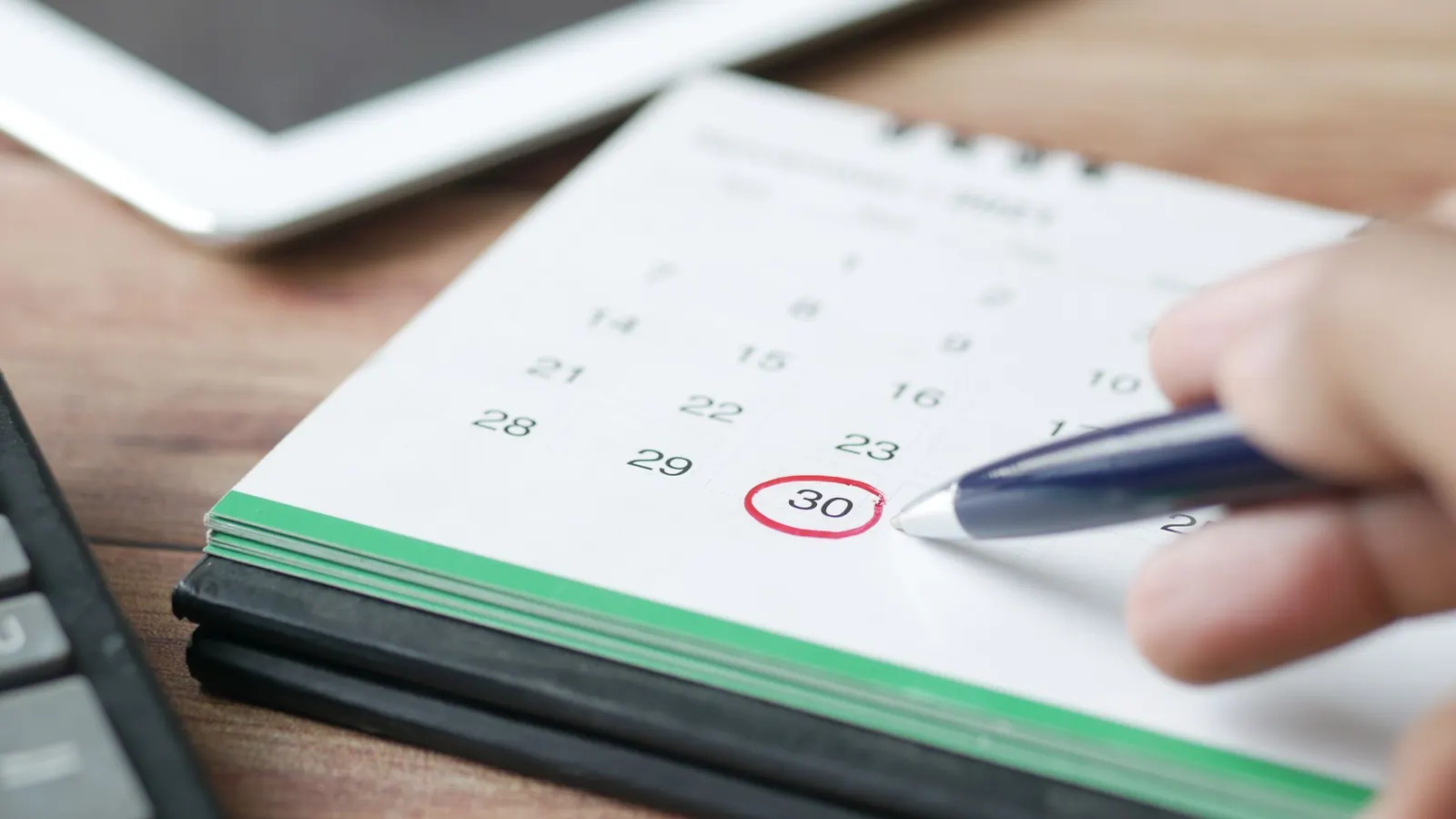 Eine Hand kreist mit dem Stift einen Tag im Kalender ein – Dauerfristverlängerung